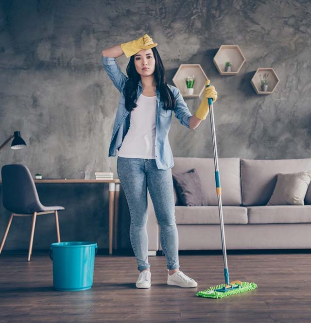 woman cleaning taking majority of home work load in relationship, looking tired