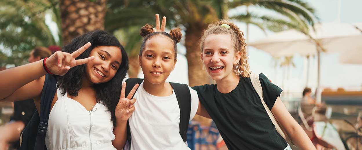 three preteen female children socializing by being goofy and posing for photo