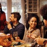 holiday guests at thanksgiving dinner laughing