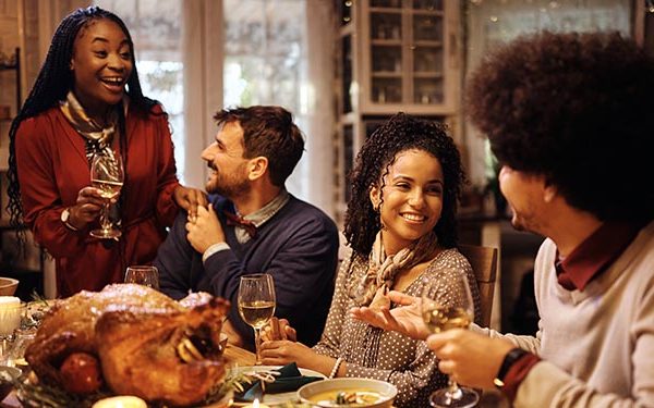 holiday guests at thanksgiving dinner laughing