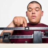 overweight man on scale considering ozempic weight loss drug