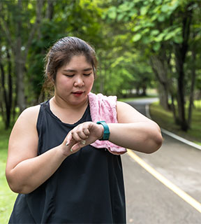 Woman on walk checking fitbit