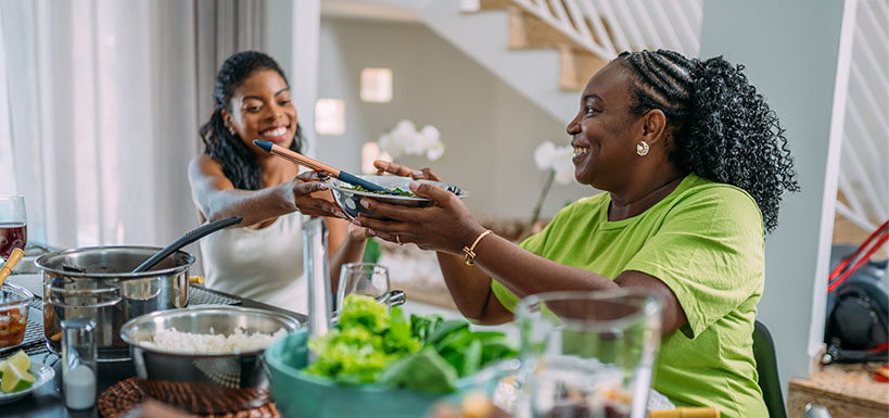 women eating passing plate
