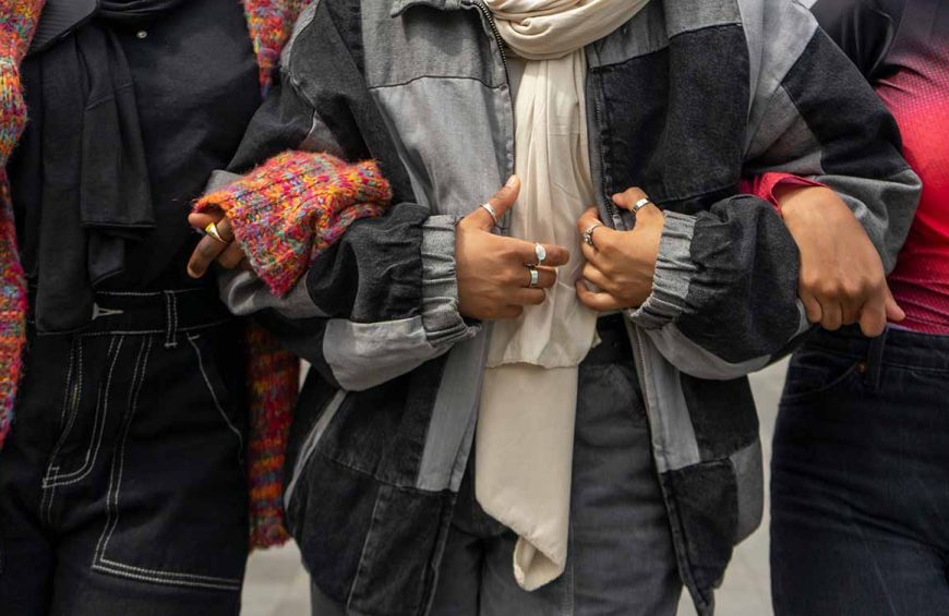 3 women in scarves linking arms