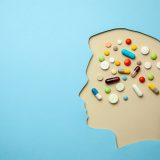 graphical depiction of a brain with variety of drugs and pills