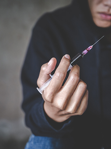 addicted man about to shoot up drugs with a needle
