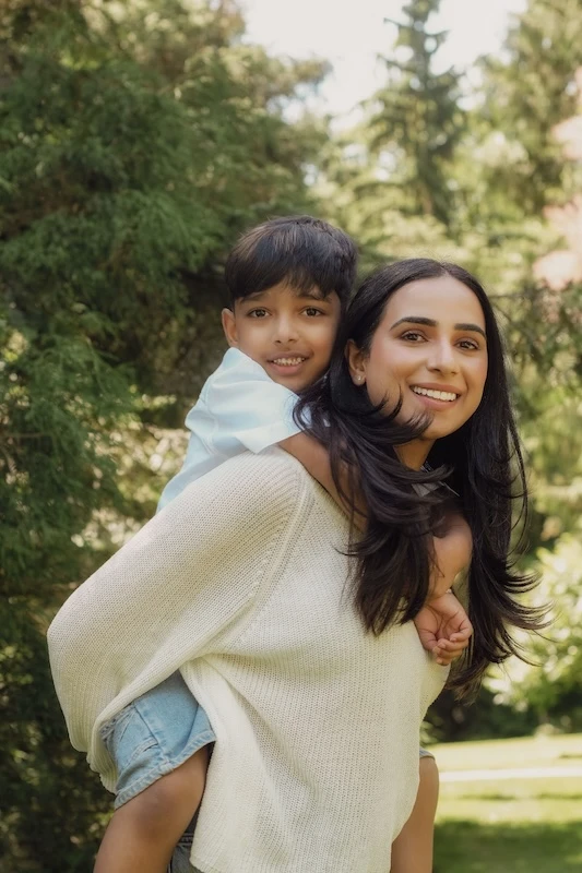A woman carrying her son on her back.