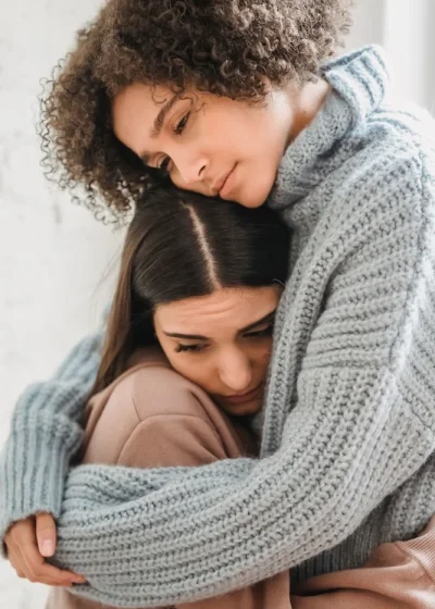 Two women embracing each other.