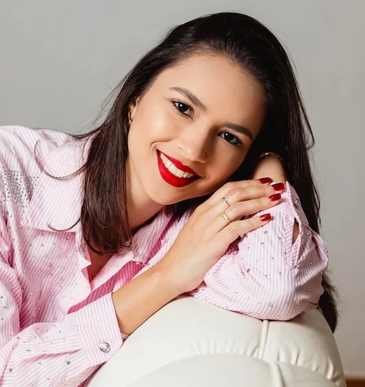 PrasadCounselingAndTraining-latina-woman-leaning-and-smiling A latina woman leaning on the back of a couch and smiling.